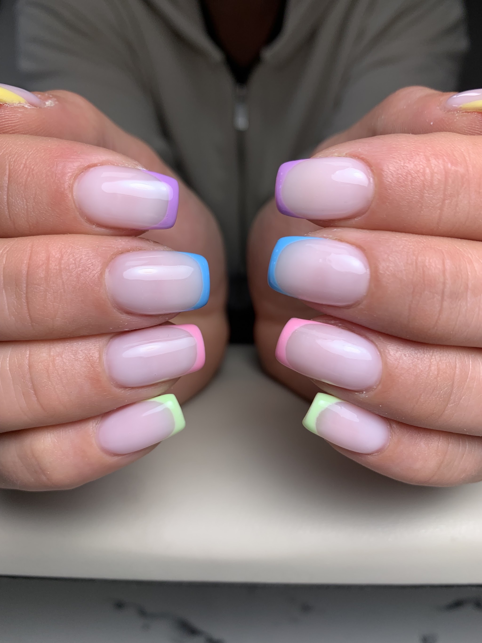 Korte, vierkante nagels met een pastel French in regenboogtinten